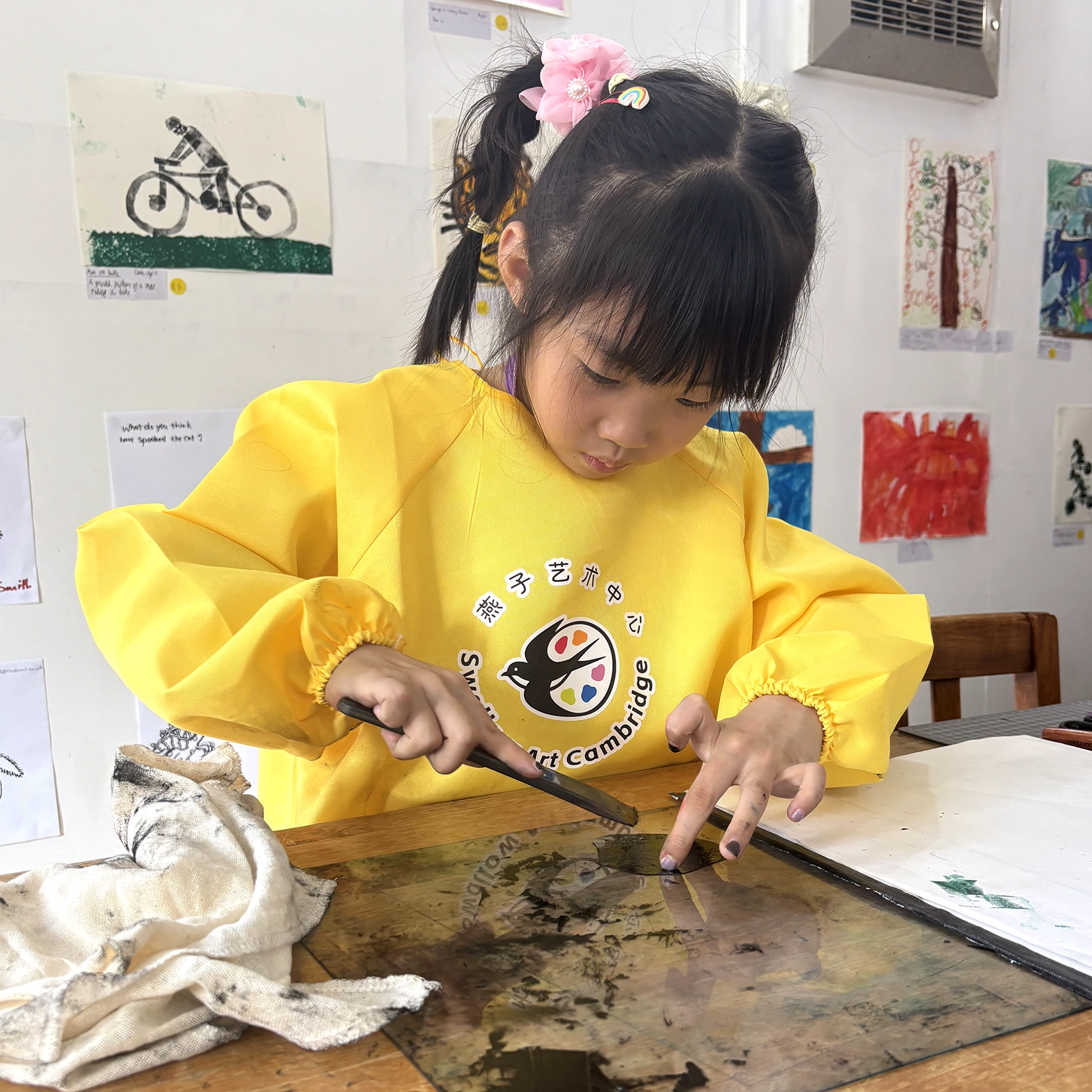 A student inking a printing plate during a one-to-one lesson at Swallow Art Cambridge